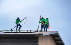 azienda specializzata nella pulizia di pannelli solari che si appresta a pulirli sopra un tetto